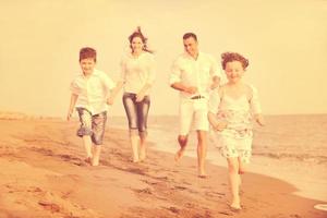 feliz jovem família se divertir na praia foto