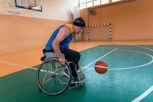 Veteranos de guerra com deficiência equipes de basquete de raça mista e idade em cadeiras de rodas jogando uma partida de treinamento em um ginásio de esportes. conceito de reabilitação e inclusão de pessoas com deficiência foto