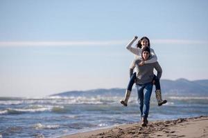 casal se divertindo na praia durante o outono foto