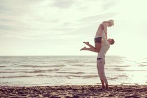 amando o jovem casal em uma praia em dia ensolarado de outono foto