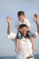 feliz pai e filho se divertem e aproveitam o tempo na praia foto