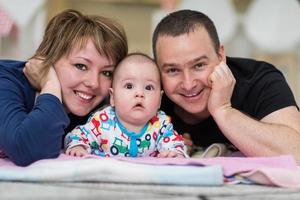 retrato de jovem casal feliz com seu adorável bebê foto