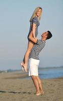 feliz casal jovem tem tempo romântico na praia foto