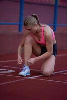 mulher desportiva na pista de corrida atlética foto