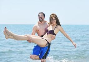 feliz casal jovem tem tempo romântico na praia foto