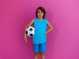 retrato de jovem árabe com bola de futebol isolada contra fundo rosa e espaço de cópia foto