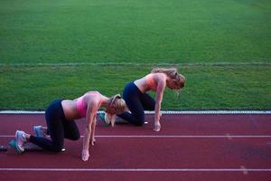 grupo de mulheres correndo na pista de atletismo desde o início foto