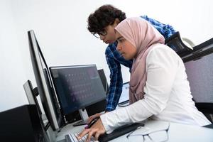 negócios de inicialização, equipe de jovens profissionais criativos discutindo sobre reunião no escritório brilhante enquanto aponta no computador com tela de monitor duplo para sugestões e ajuda no projeto foto