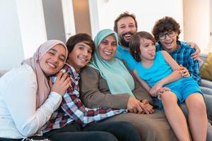 foto de retrato de uma família muçulmana árabe sentado em um sofá na sala de uma grande casa moderna. foco seletivo