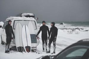 surfistas do ártico em roupa de mergulho depois de surfar de minivan foto