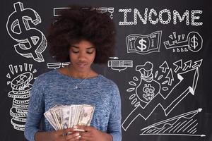 mulher negra segurando dinheiro em fundo cinza foto