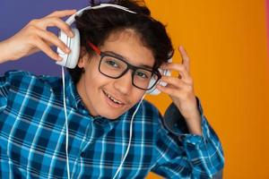 adolescente usando fones de ouvido e ouvindo música fundo roxo foto