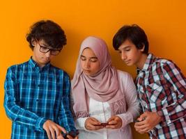 grupo de adolescentes árabes usando telefones inteligentes para redes de mídia social e compartilhamento de informações para educação online foto