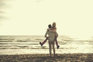 amando o jovem casal em uma praia em dia ensolarado de outono foto