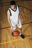 jogador de jogo de bola de basquete no pavilhão desportivo foto