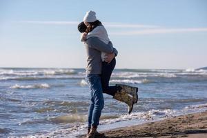 amando o jovem casal em uma praia em dia ensolarado de outono foto