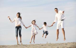 feliz jovem família se divertir na praia foto