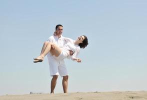 feliz casal jovem se divertir na praia foto