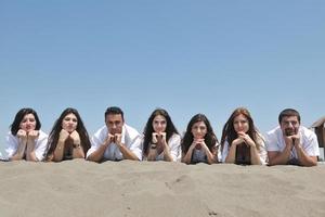 grupo de jovens felizes em se divertir na praia foto