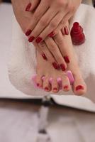 pés e mãos femininos no salão spa foto