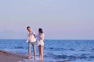 jovem casal na praia se divertir foto