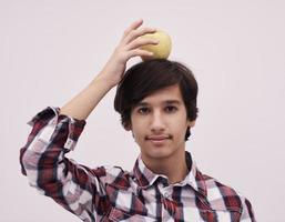 retrato de um jovem adolescente com uma maçã na cabeça foto