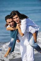 feliz casal jovem se diverte na bela praia foto