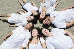 grupo de jovens felizes em se divertir na praia foto