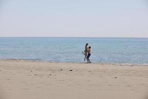 feliz casal jovem se divertir na praia foto