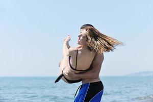 feliz casal jovem se divertir na praia foto