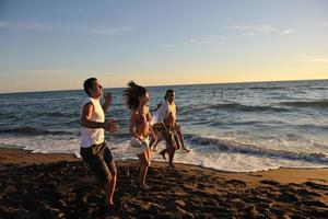 grupo de pessoas correndo na praia foto