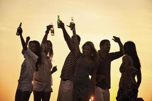 grupo de jovens aproveita a festa de verão na praia foto