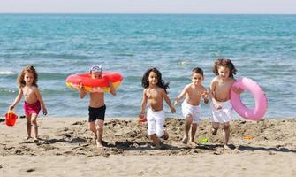 grupo infantil se diverte e brinca com brinquedos de praia foto