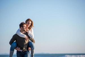 casal se divertindo na praia durante o outono foto