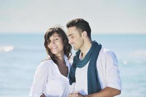 feliz casal jovem se diverte na bela praia foto