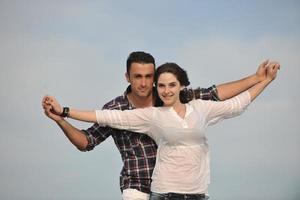 feliz casal jovem se divertir na praia foto