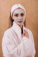 mulher de spa aplicando máscara facial foto