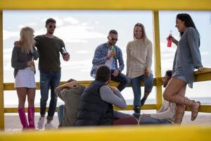 grupo de amigos se divertindo no dia de outono na praia foto