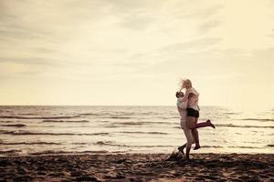 amando o jovem casal em uma praia em dia ensolarado de outono foto