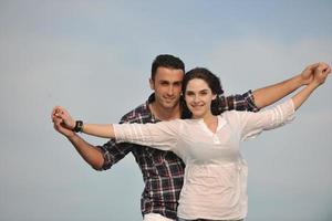 feliz casal jovem se divertir na praia foto