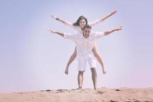 feliz casal jovem se divertir na praia foto