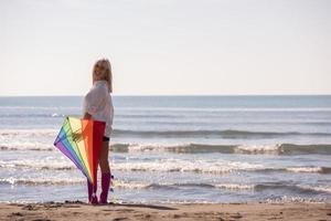 jovem mulher com pipa na praia em dia de outono foto