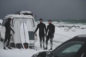 surfistas do ártico em roupa de mergulho depois de surfar de minivan foto