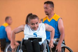 uma jovem jogando basquete em cadeira de rodas em um time profissional. igualdade de gênero, o conceito de esportes com deficiência. foto