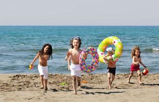 grupo infantil se diverte e brinca com brinquedos de praia foto