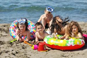 grupo infantil se diverte e brinca com brinquedos de praia foto