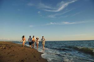 grupo de pessoas correndo na praia foto