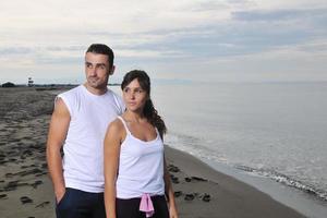 feliz casal jovem se diverte na bela praia foto