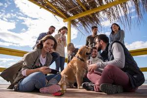 grupo de amigos se divertindo no dia de outono na praia foto