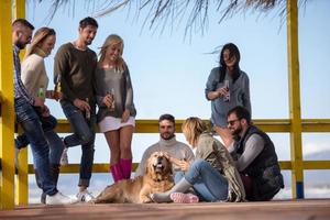 grupo de amigos se divertindo no dia de outono na praia foto